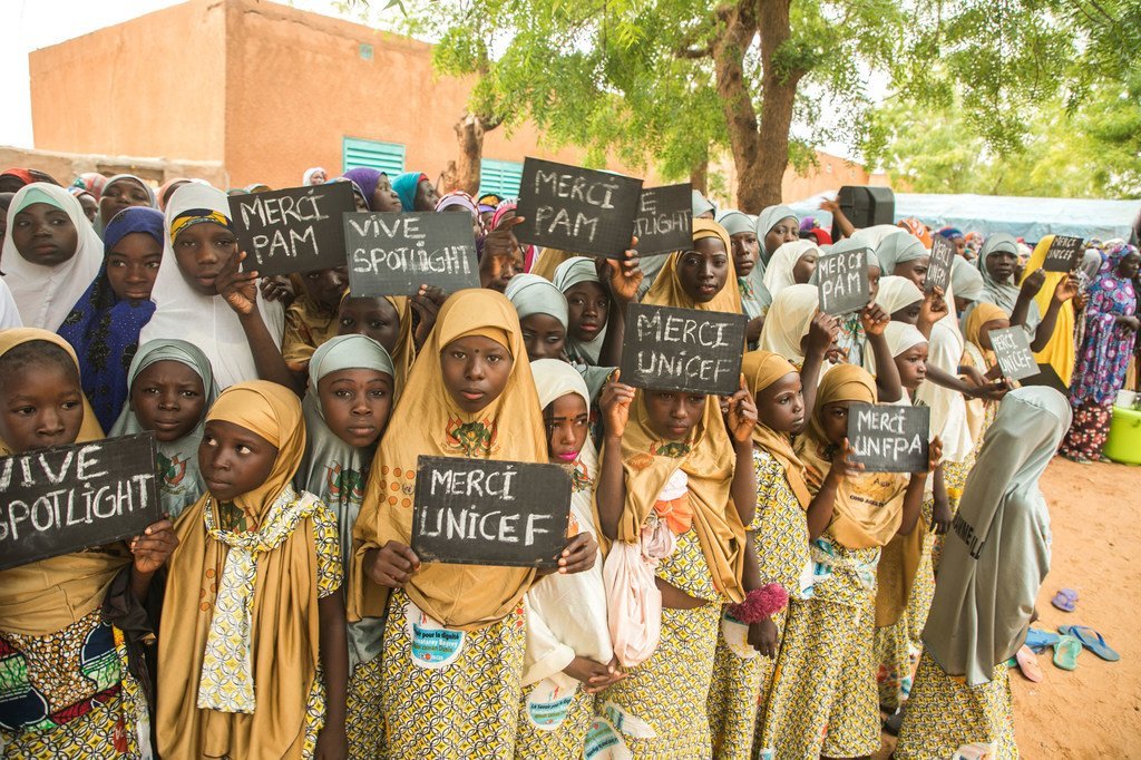 Young girls in the village of Danja in Niger hold signs in support of the Spotlight Initiative.